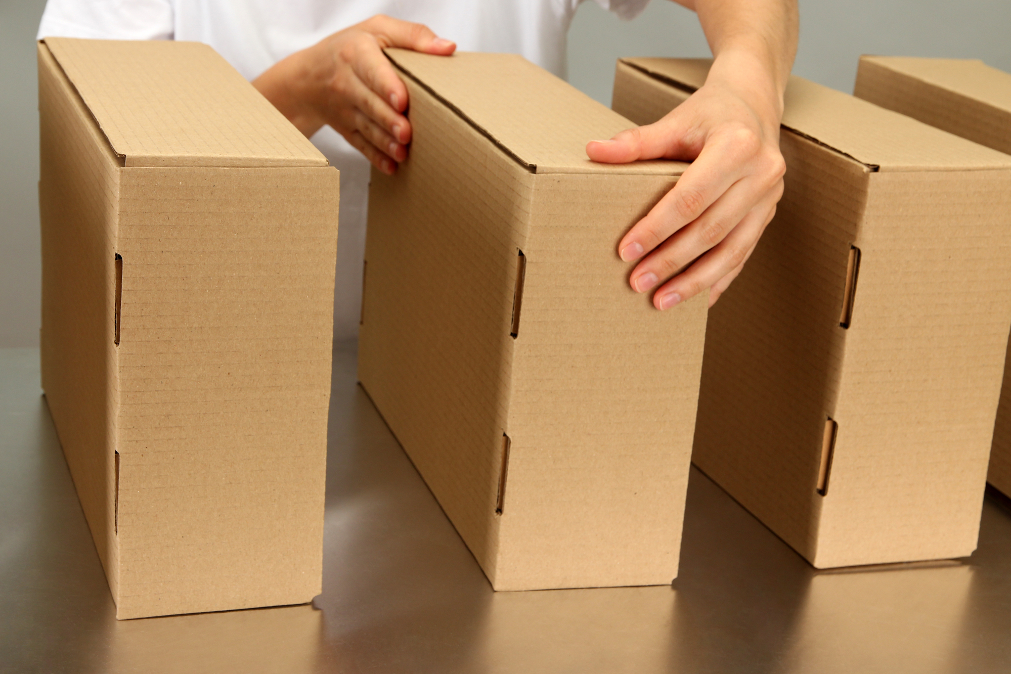 Worker working with boxes at conveyor belt, on grey background